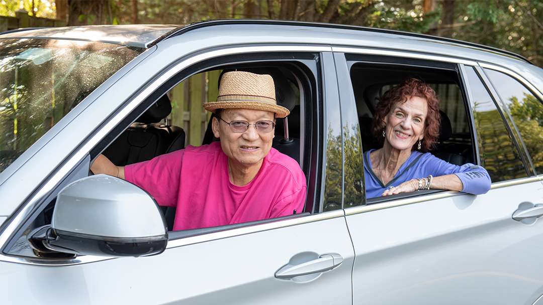 A gentleman provides a ride to an aging woman who is need of transportation to get around town. Both are smiling because transportation for seniors is now solved!